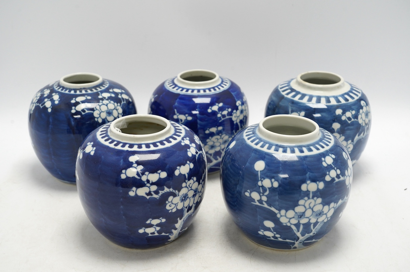 Five Chinese blue and white prunus jars, without covers, early 20th century, tallest 13cm high. Condition - one jar is chipped around the top, another has a large firing fault, the other two good